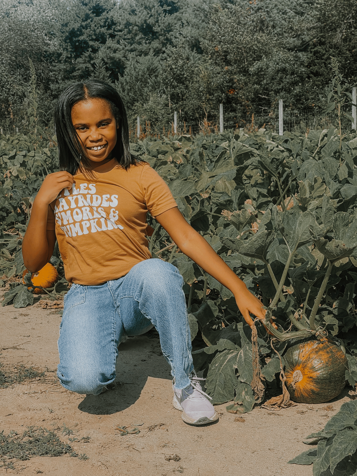 Kid Modeling Apples, Hayrides, S'mores, and Pumpkins Shirt in Toast