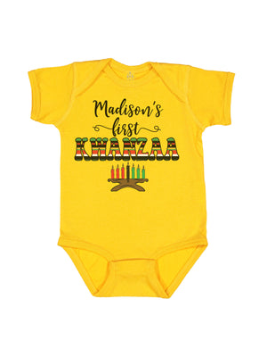 Yellow short sleeve infant one piece with Madison's first Kwanzaa in African print