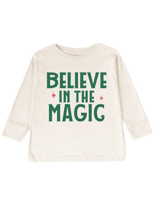 An off-white long-sleeve t-shirt with 'BELIEVE IN THE MAGIC' printed in green and red on the front, displayed against a solid white background.