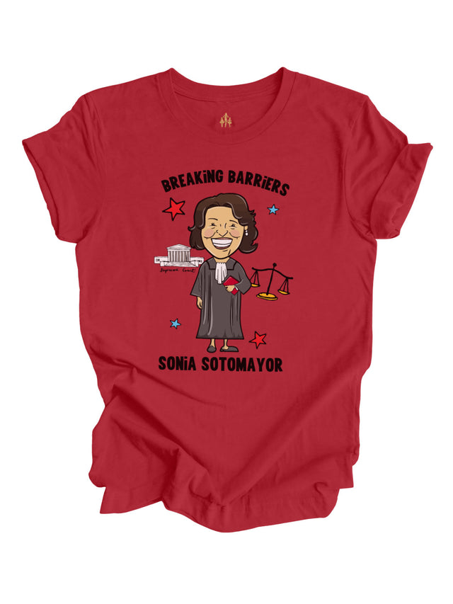 Red Women’s History Month t-shirt featuring an illustrated Sonia Sotomayor with “Breaking Barriers” text, Supreme Court graphics, and justice scales.

