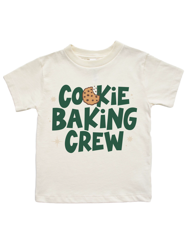 An off-white short-sleeve t-shirt with a graphic that reads 'COOKIE BAKING CREW' in dark green letters, featuring a chocolate chip cookie illustration inside the letter 'O'.