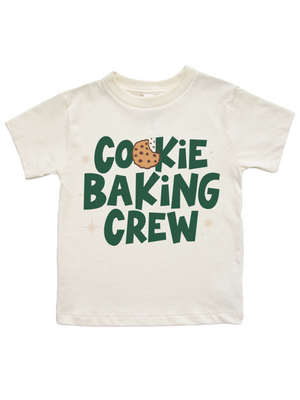 An off-white short-sleeve t-shirt with a graphic that reads 'COOKIE BAKING CREW' in dark green letters, featuring a chocolate chip cookie illustration inside the letter 'O'.