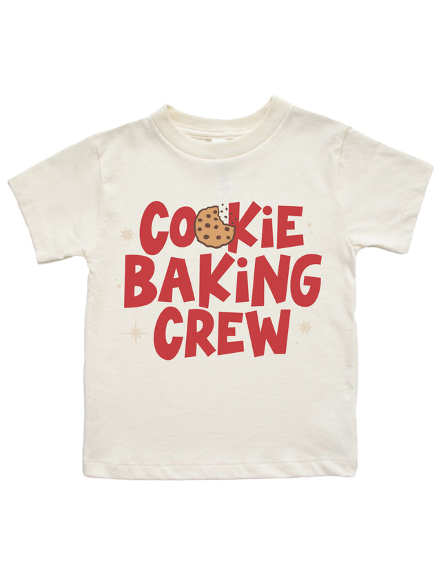 An off-white short-sleeve kids' t-shirt featuring a red graphic print that reads 'COOKIE BAKING CREW' with a chocolate chip cookie illustration replacing the letter 'O' in 'COOKIE'.