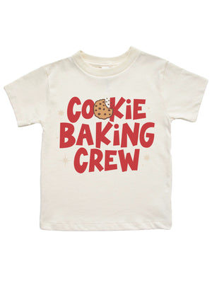 An off-white short-sleeve kids' t-shirt featuring a red graphic print that reads 'COOKIE BAKING CREW' with a chocolate chip cookie illustration replacing the letter 'O' in 'COOKIE'.