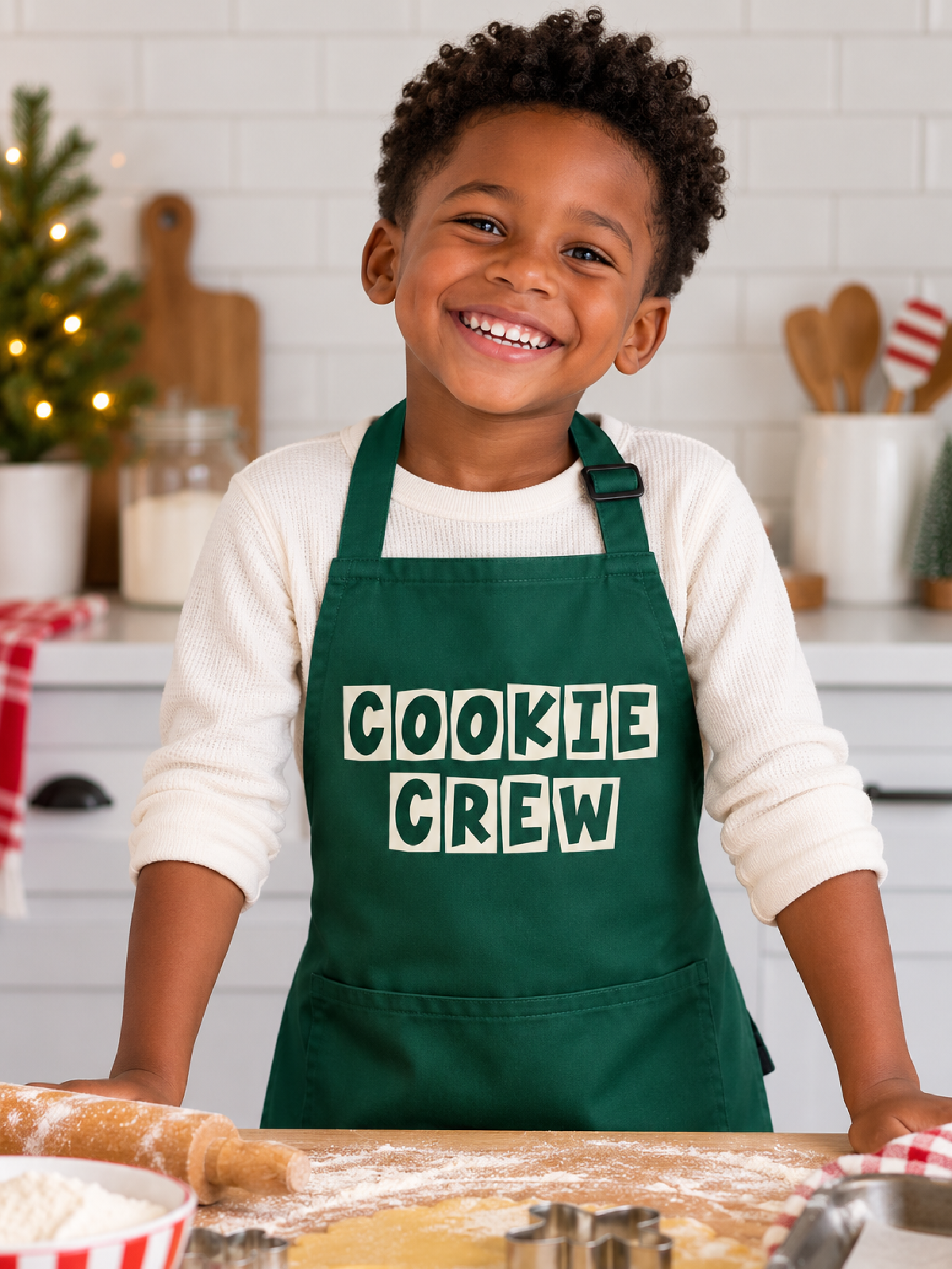 Kid wearing Cookie Crew green apron while baking