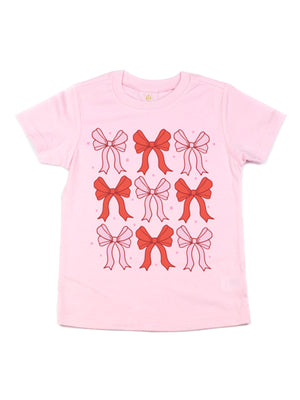 Pink girls Valentine’s Day shirt featuring a custom red and pink bows design, made from 100% cotton, displayed flat on a white background.