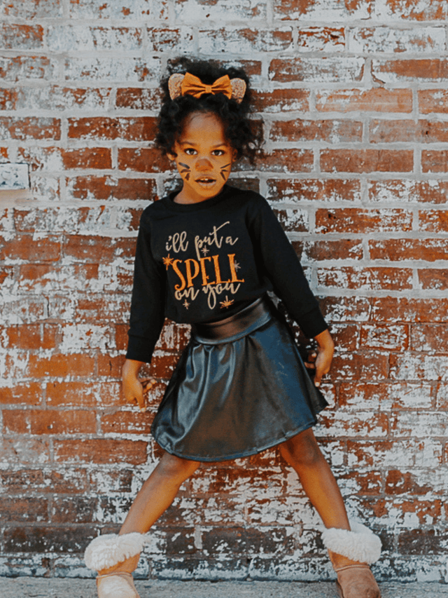 Toddler girl dressed in black “I’ll Put a Spell on You” Halloween shirt with costume accessories