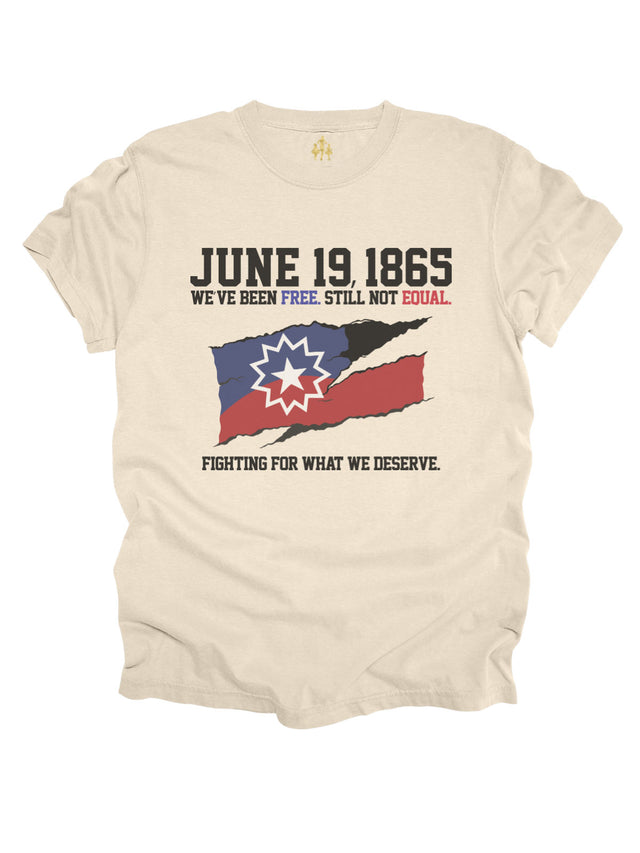 Cream Juneteenth shirt with torn flag graphic and text “June 19, 1865 – We’ve Been Free. Still Not Equal. Fighting for What We Deserve.”