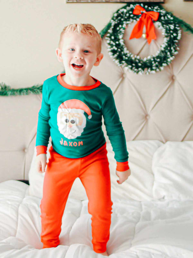 Boy wearing personalized green and red holiday pajamas