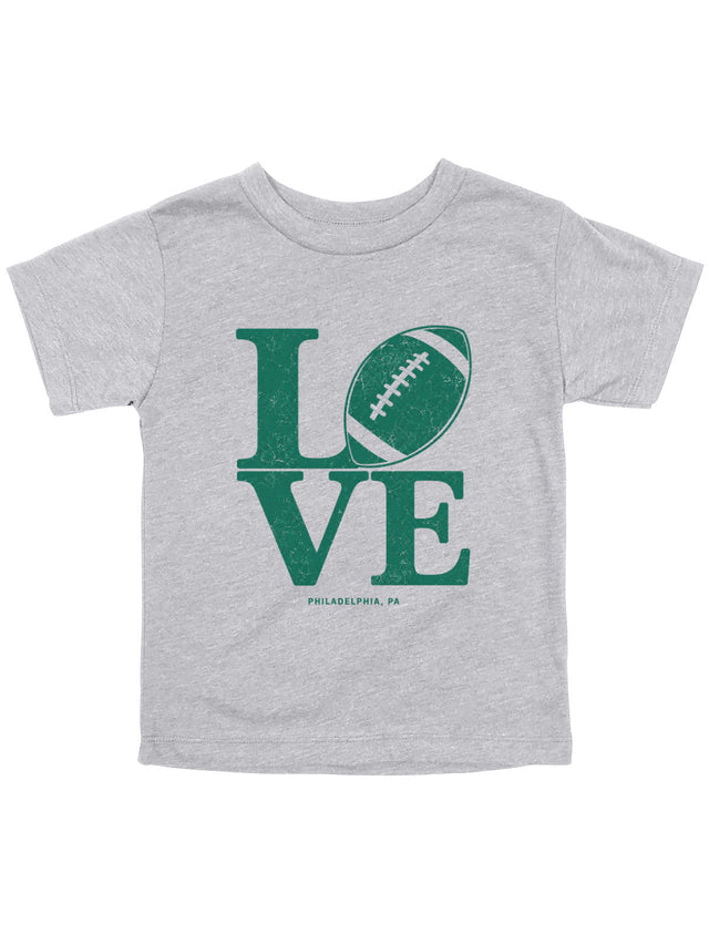 A toddler heather gray t-shirt featuring a green graphic that spells 'LOVE' with a football representing the letter 'O', and 'PHILADELPHIA, PA' printed below.