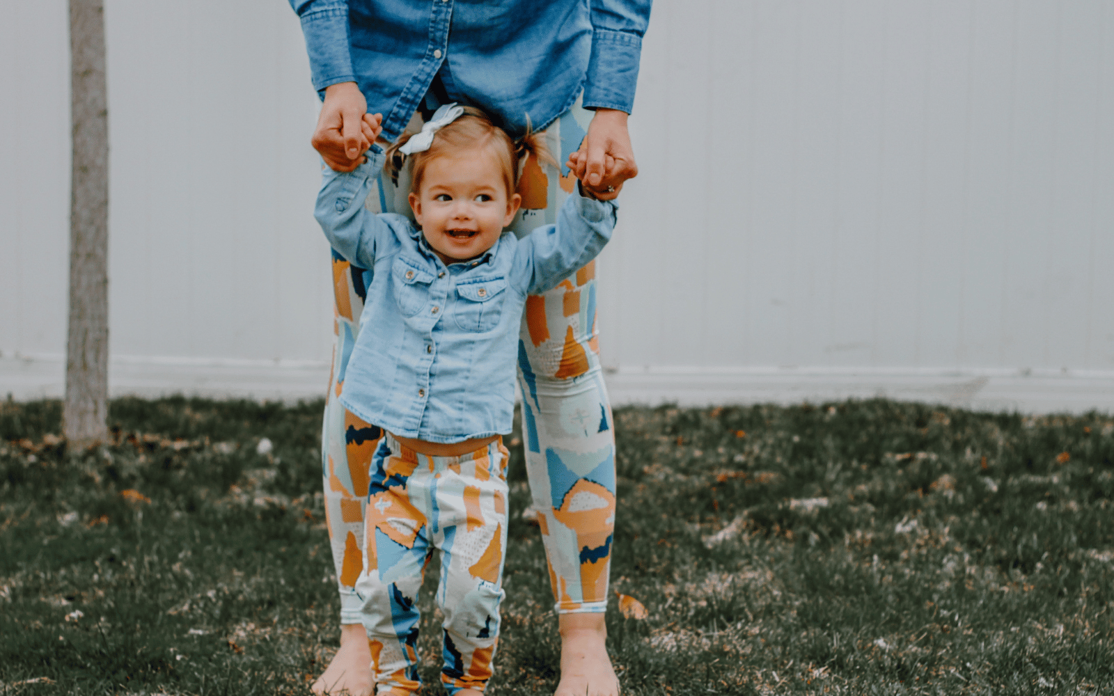 Woman holding little girls hand, wearing matching paint splatter leggings