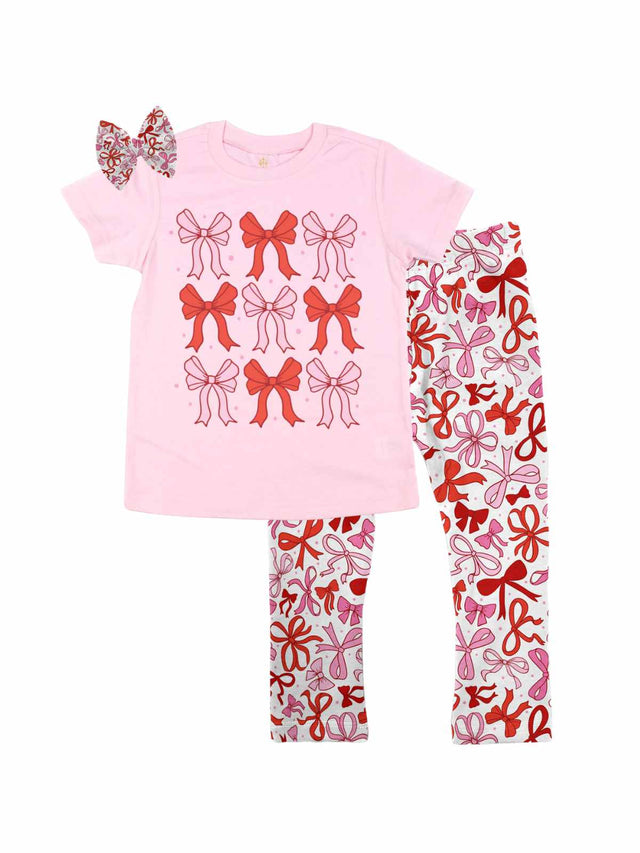 Pink girls Valentine’s Day shirt with a red and pink coquette bows design, paired with matching white leggings featuring red and pink bows, and styled with a coordinating bow hair accessory, displayed flat on a white background.