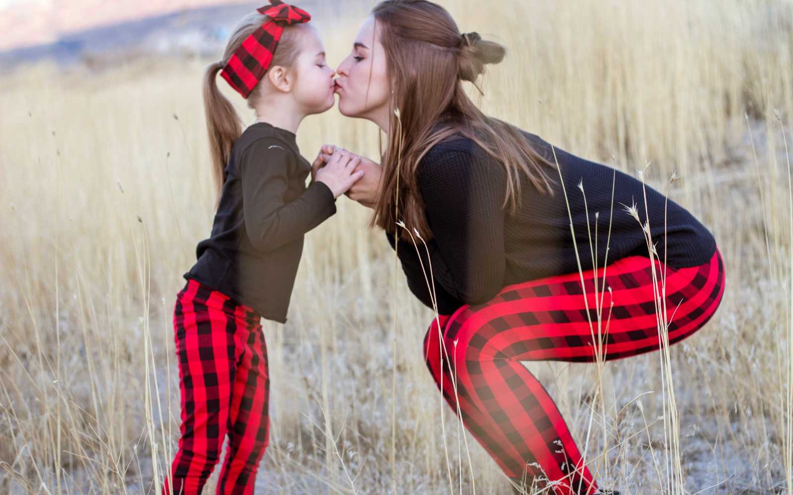 Matching mother and daughter in red buffalo plaid holiday leggings and headband