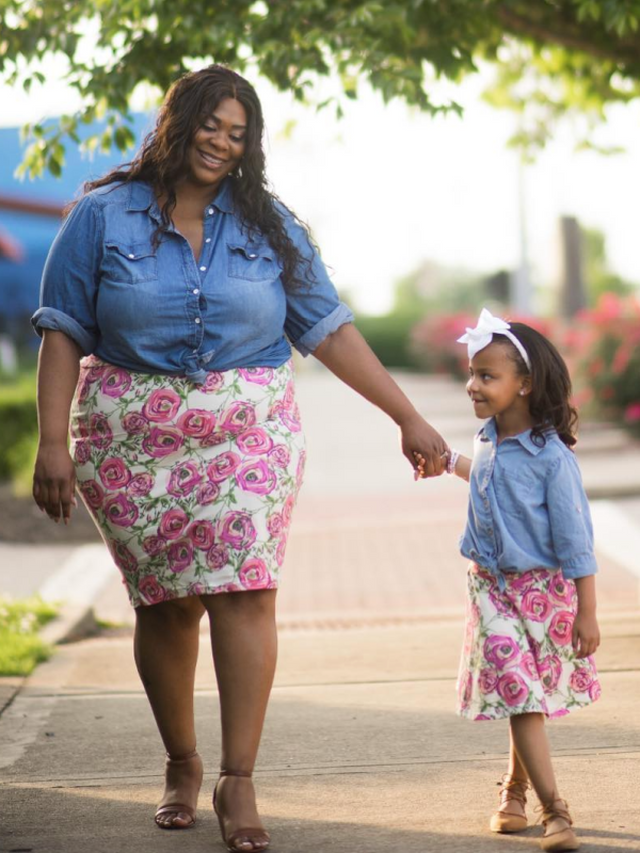 Mom and daughter wearing matching floral skirts—mom in a pencil skirt, daughter in a circle skirt—walking hand in hand in spring sunshine