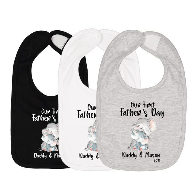 Three baby bibs in black, white, and gray with elephant graphic and text “Our First Father’s Day