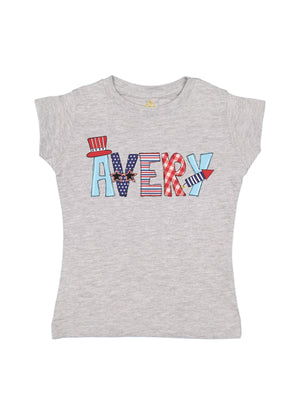 Gray girls’ t-shirt with custom name “Khloe” in red, white, and blue patriotic prints, including stars, stripes, and bows