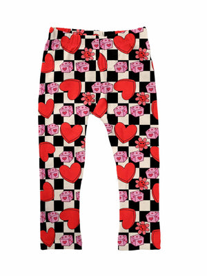 Girls Valentine’s leggings with a checkered pattern featuring red hearts, pink dice, and flowers, made from custom double-brushed poly fabric, displayed flat on a white background.