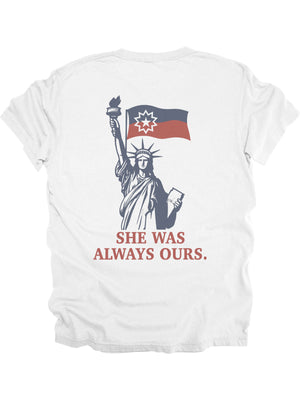 Back of white adult Juneteenth shirt featuring Lady Liberty holding the Juneteenth flag with bold text “She Was Always Ours”