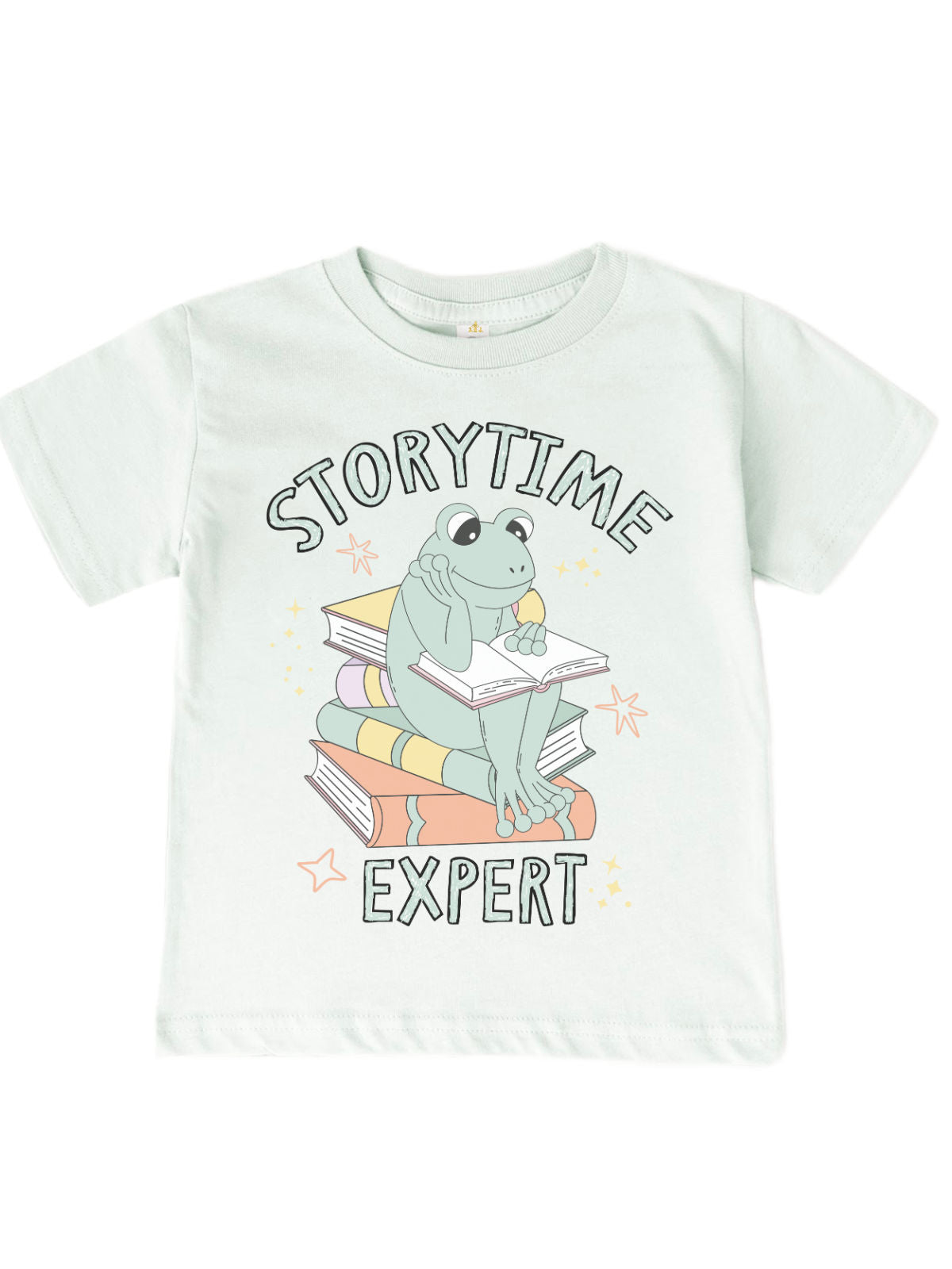 Kids' spring shirt in banana yellow featuring a cute reading frog sitting on a stack of books with "Storytime Expert" text. Soft 100% cotton, unisex fit.