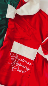 Folded green and white silk pajamas with Christmas Morning Crew pocket detail