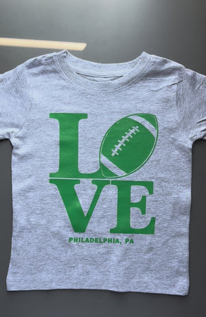 Kids LOVE Football Philadelphia shirt featuring a football-inspired LOVE design on white and heather gray tees
