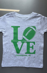 Kids LOVE Football Philadelphia shirt featuring a football-inspired LOVE design on white and heather gray tees