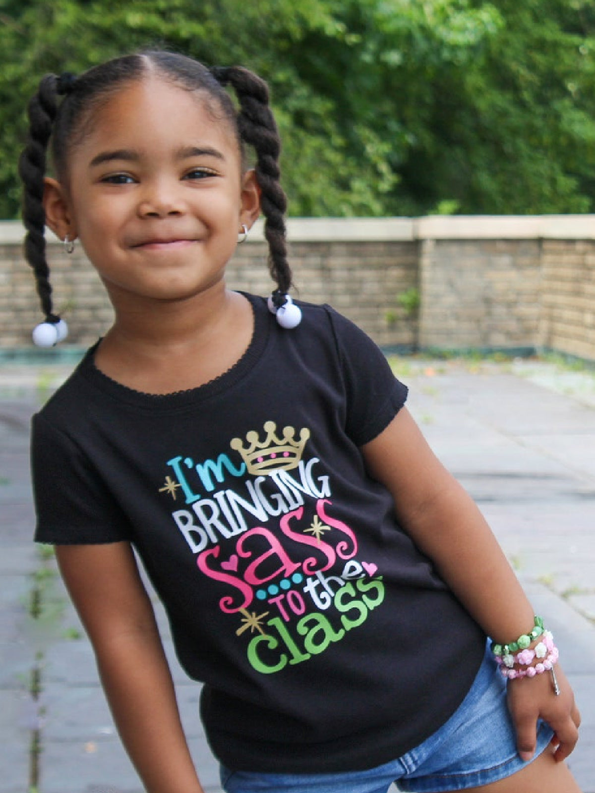 Black girls’ t-shirt with colorful “I’m Bringing Sass to the Class” design featuring a gold crown – also available in white and long sleeve options