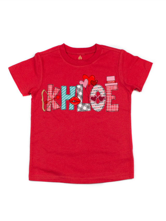 Custom kids Valentine's Day shirt in red, short sleeve that reads Khloe in festive font with bow and arrow, red lips, and heart balloons.